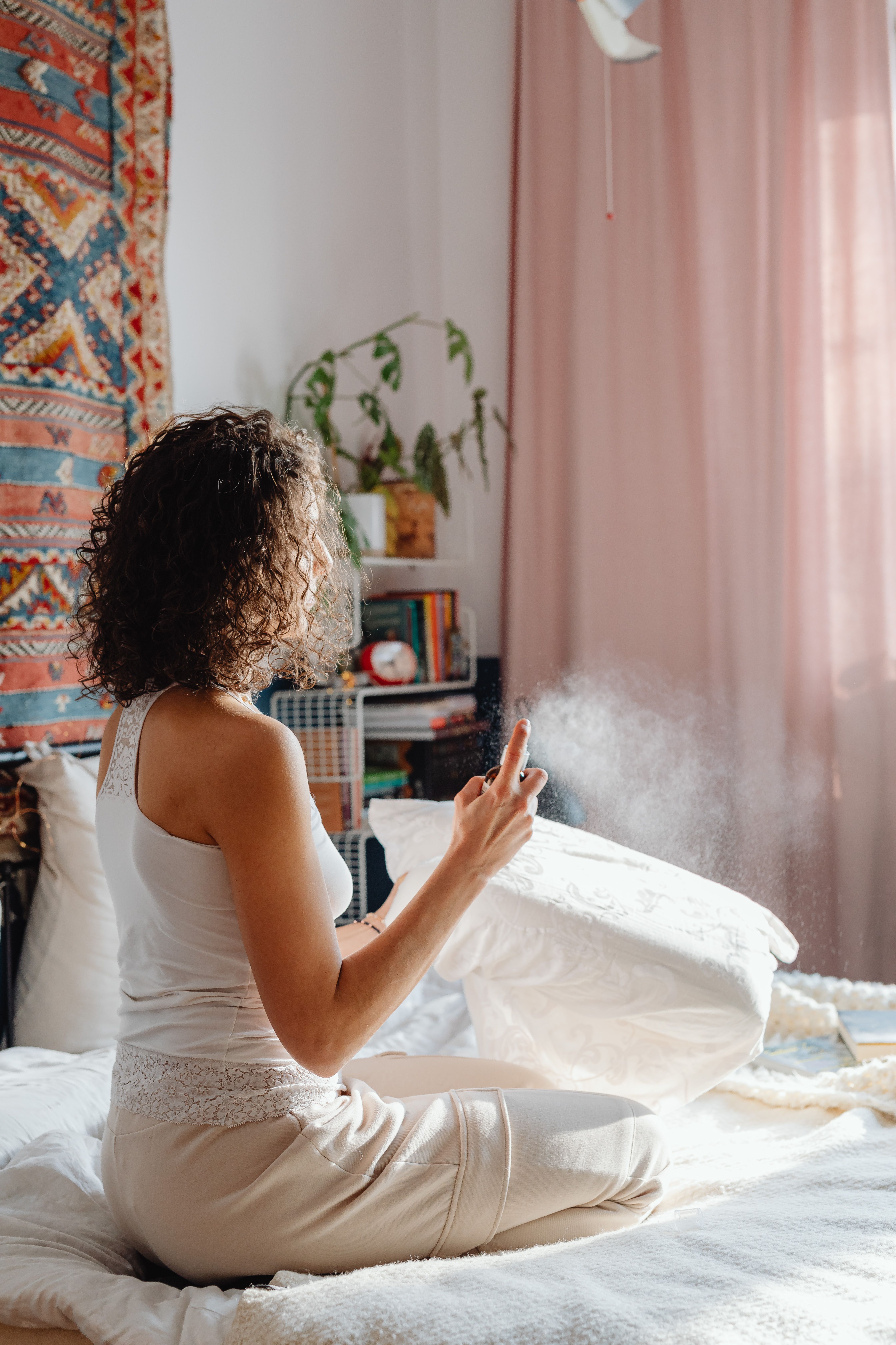 A woman refreshing a white pillow as part of a regular pillow-care routine