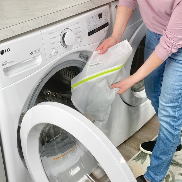 Technical activewear being protected in a mesh laundry bag before a machine wash