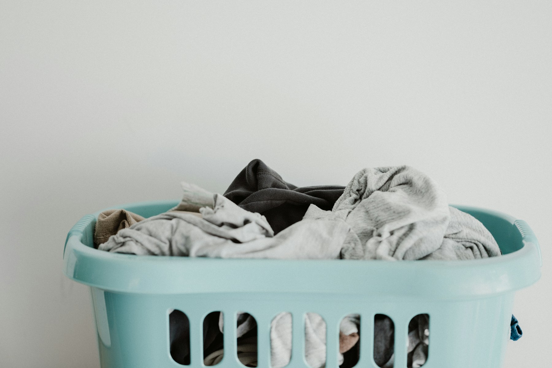 Worn shirts in a laundry basket, ready to be checked for sweat odour before washing.
