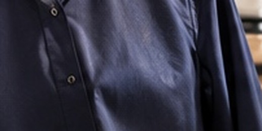 A navy cotton shirt on a hanger